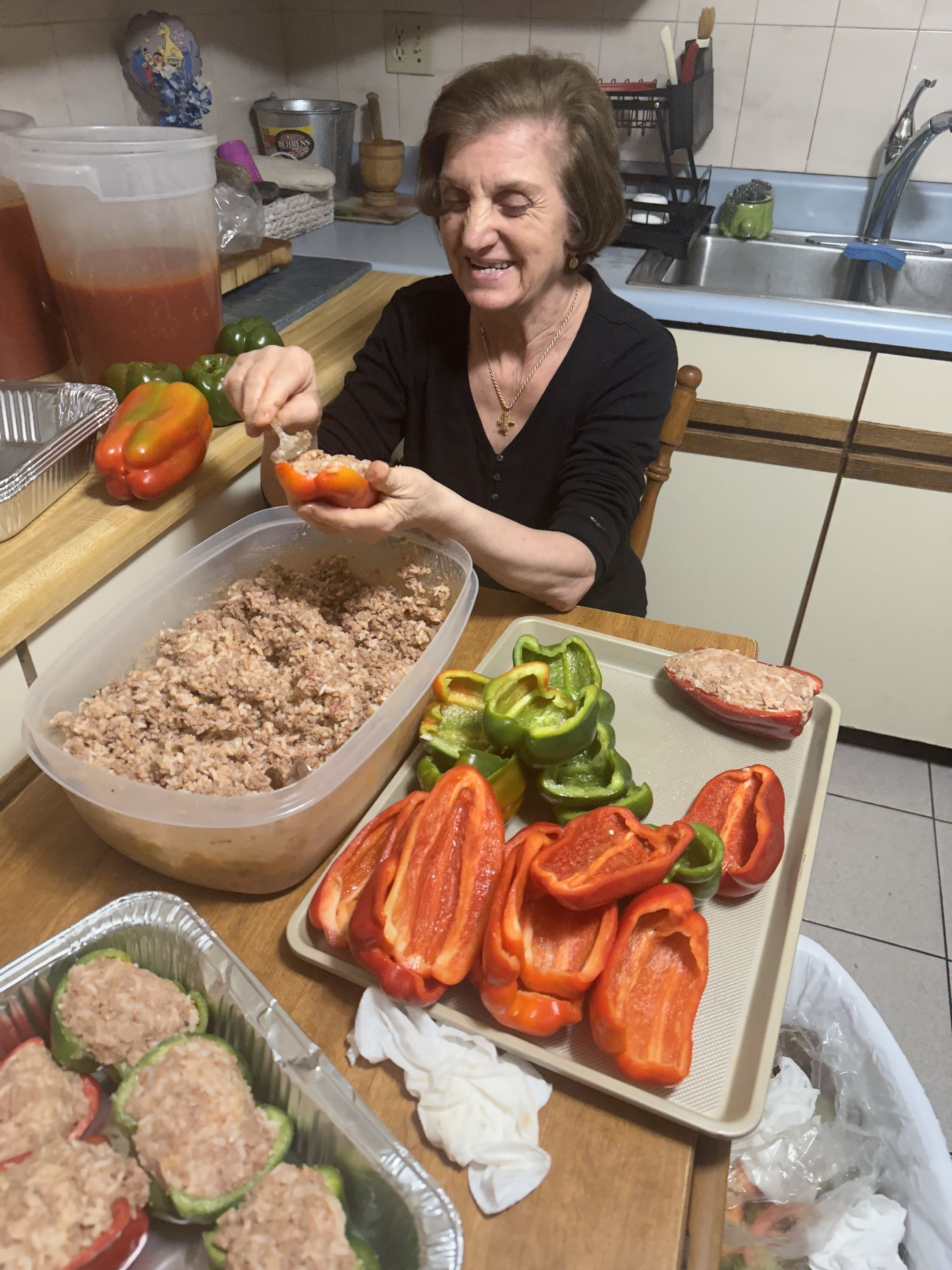 Nonna stuffing peppers by hand at the kitchen table